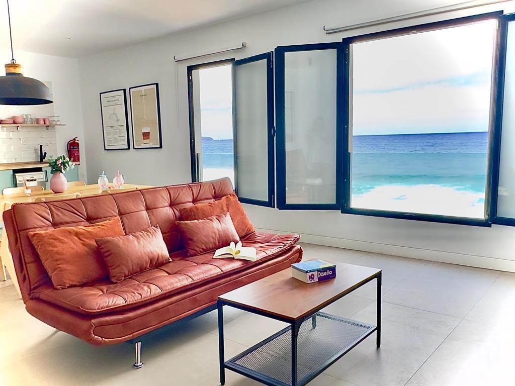 a living room with a leather couch and a table at El Submarino Coastal Home in Santa Maria de Guia de Gran Canaria