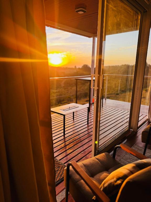 a room with a balcony with a view of the sunset at Cabana Teixeira in Cunha