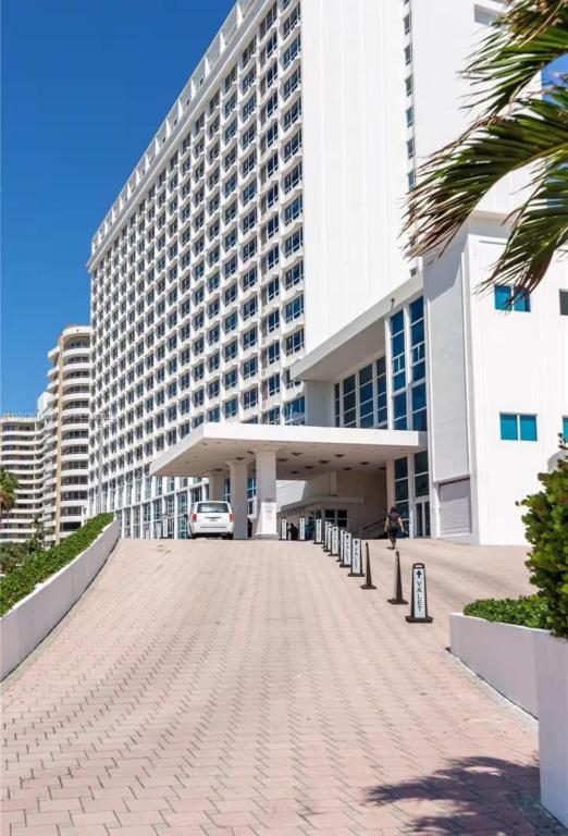 a large building with a parking lot in front of it at UNIT #908 Castle Beach Club Condominium in Miami Beach