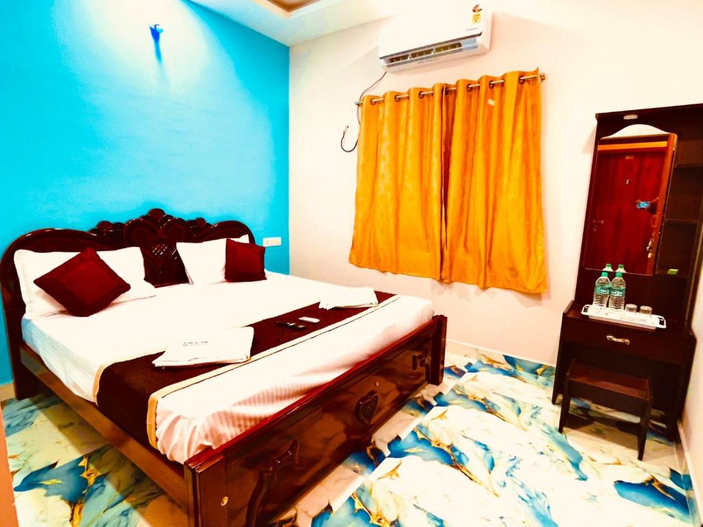1 dormitorio con cama y ventana amarilla en Nikilan Residency, en Rameswaram