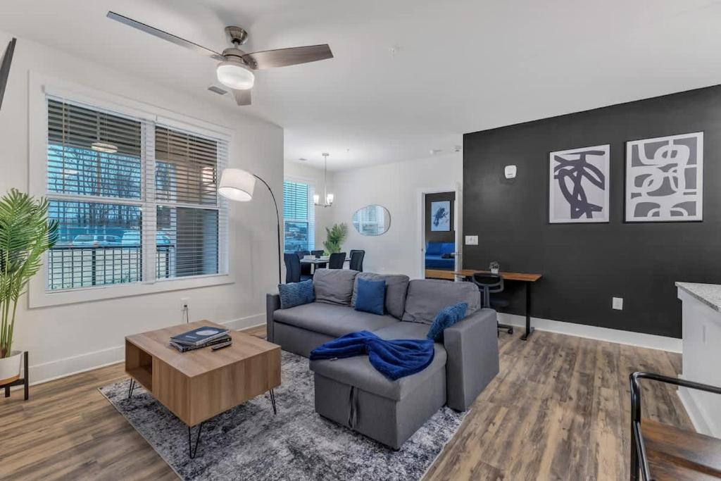 ダーラムにあるLuxe King 3BR Suite Mins to Downtown Durhamのソファとテーブルのあるリビングルーム