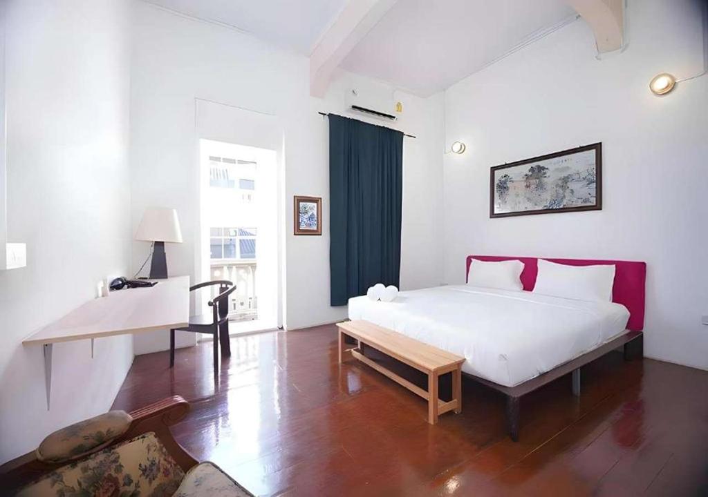 a bedroom with a large white bed and a desk at Mitr Inn Chinatown - มิตร อินน์ เยาวราช in Samphanthawong