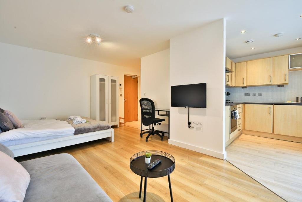 a living room with a bed and a kitchen at Modern & Bright Central Swansea Studio in Swansea