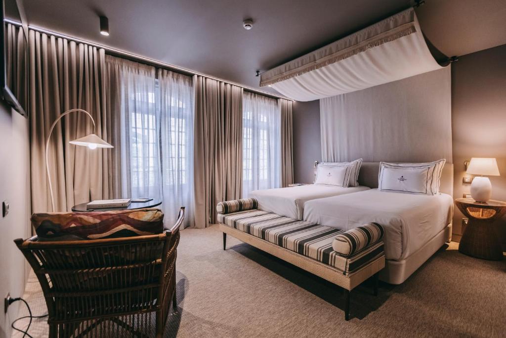 une chambre avec un grand lit et une chaise dans l'établissement Torel Terra Brava, à Angra do Heroísmo