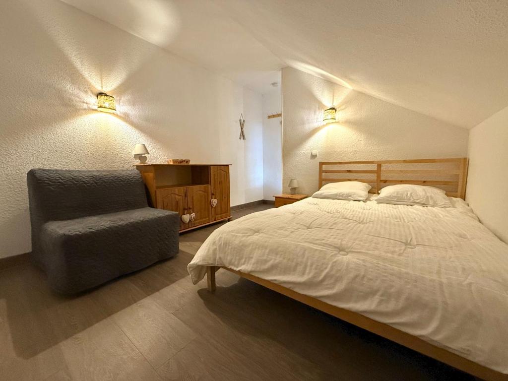 a bedroom with a bed and a chair and lights at Appartement en duplex 5-8 personnes - Les Hauts de Valmeinier A 502 in Valmeinier