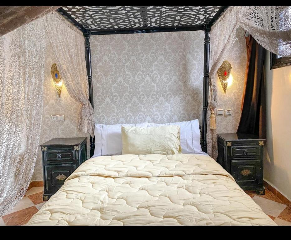 étage 2 avec terrasse vue sur mer في الجديدة: غرفة نوم بها سرير كبير وطاولتين جانبيتين