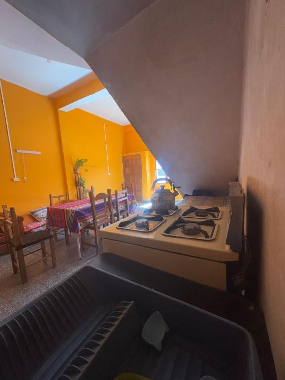 a kitchen with a stove and a dining room with a table at Hostal 'La Cholita María' in Humahuaca