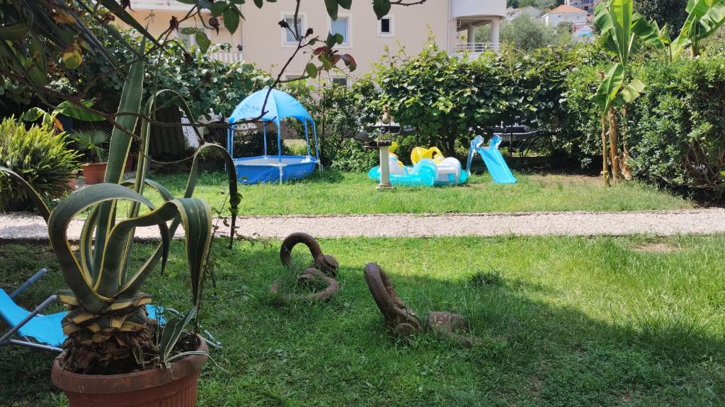 a garden with childrens play equipment in the grass at Stevova gajba in Meljine