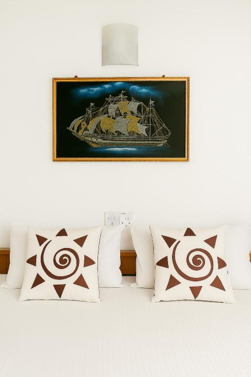 a bed with white pillows and a picture on the wall at South View residence 02 in Busse