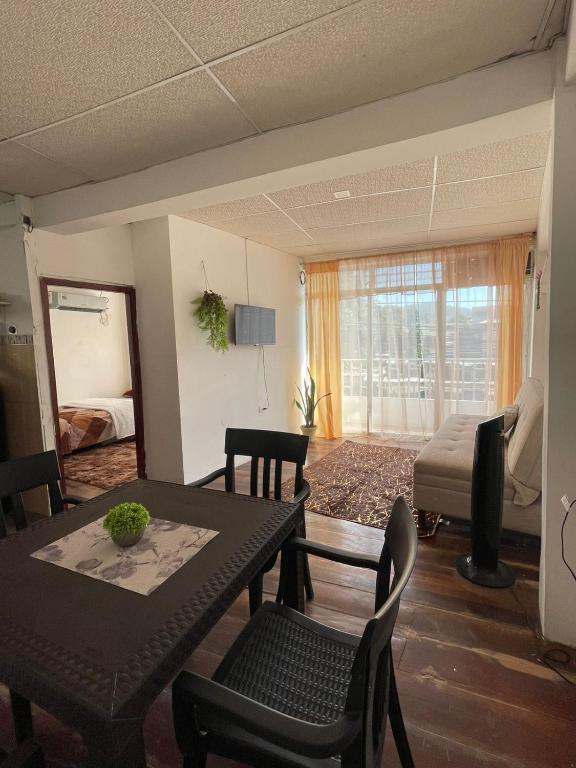 a living room with a table and chairs and a bed at SUIT PortoCentro1 in Portoviejo