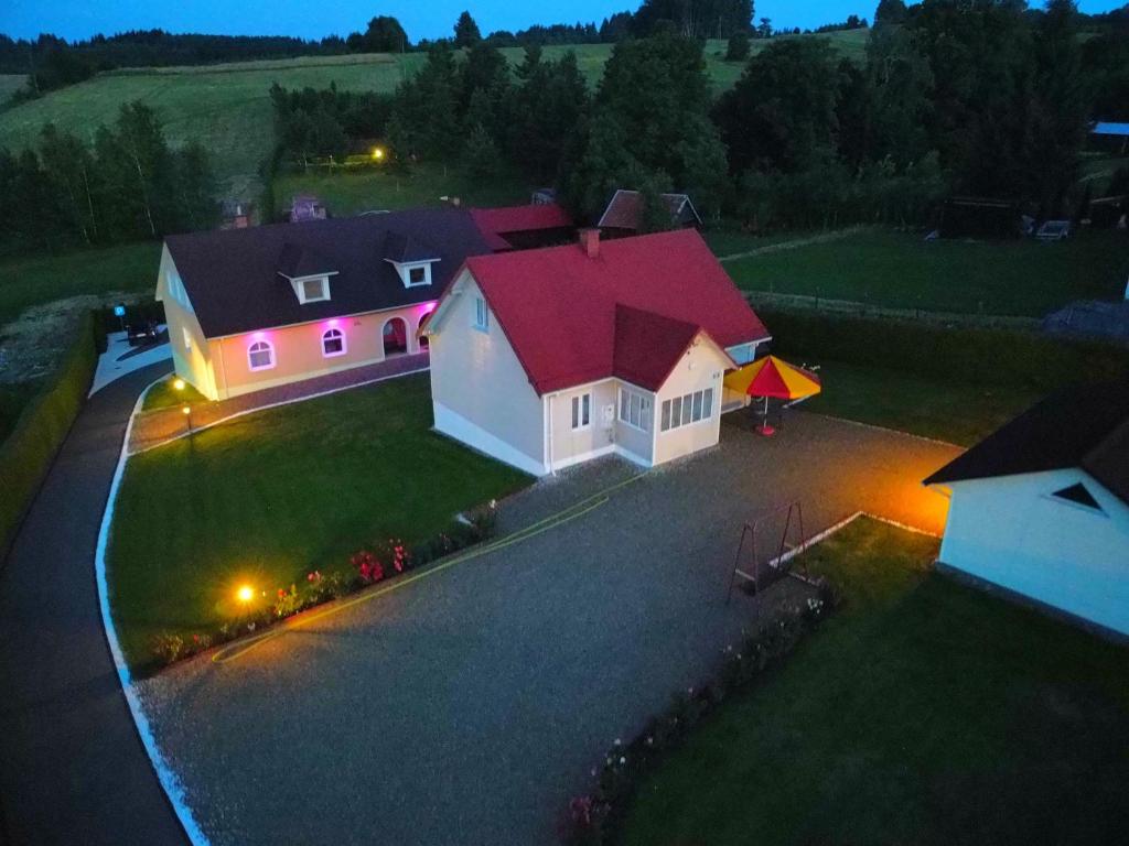 a house with a red roof with lights on it at Zielona Żabka in Polańczyk