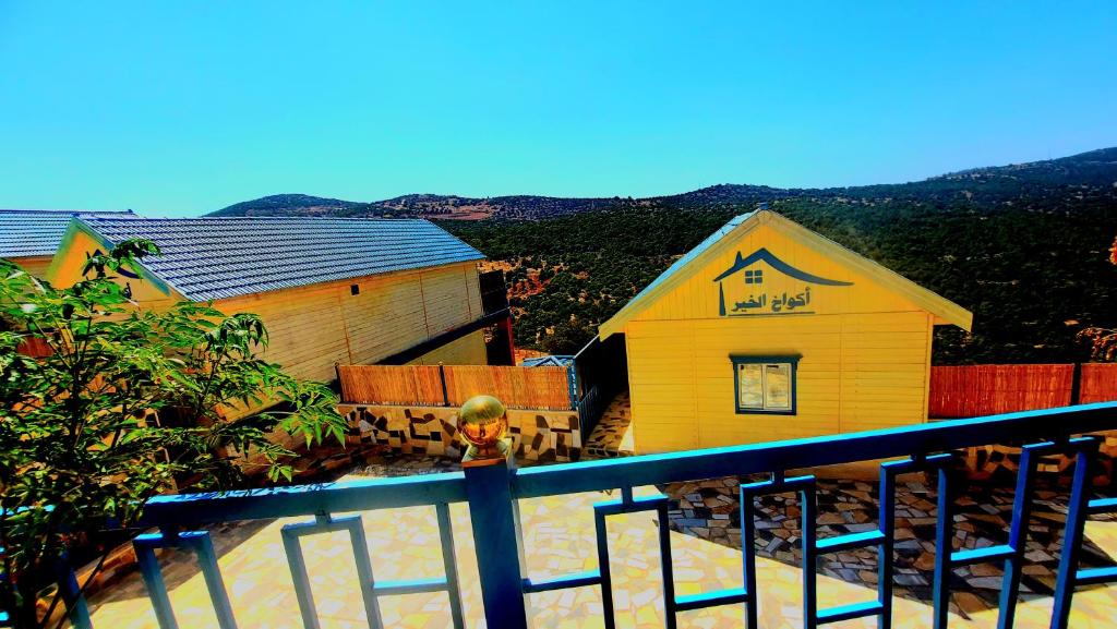 a yellow building with a sign on the side of it at اكواخ ارض الخير in Ajloun