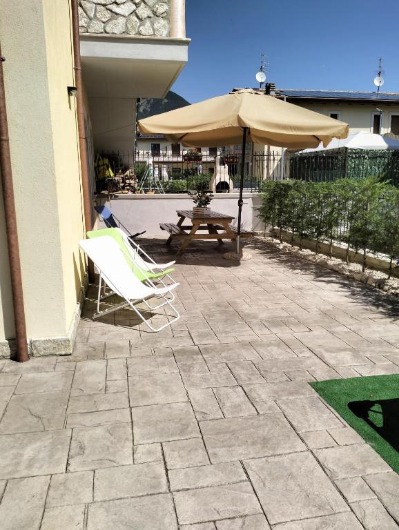 un patio con una mesa y una sombrilla en casa vitmont, en Castel di Sangro