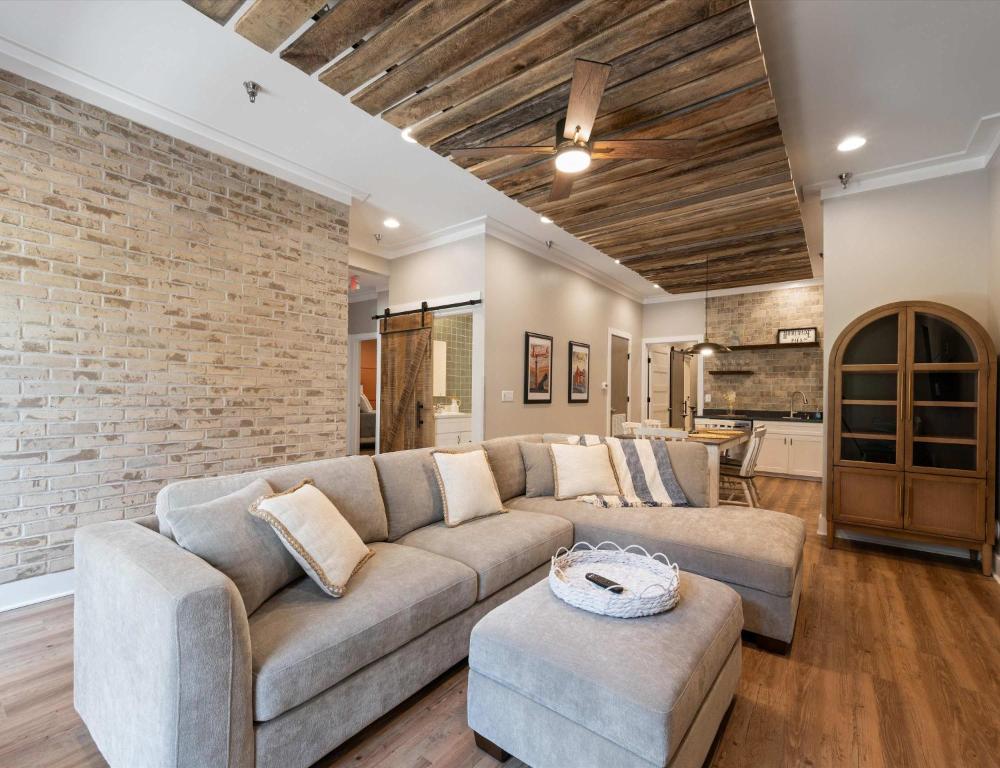 a living room with a couch and a brick wall at Carters Court Grand Escape in Franklin