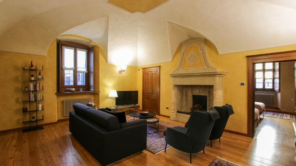 een woonkamer gevuld met meubels en een open haard bij Casa di Sant'Anselmo Aosta - Le Volte in Aosta