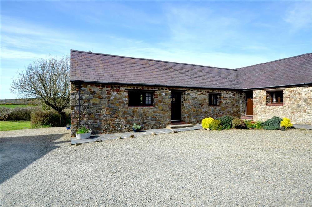 una casa de piedra con una entrada de grava delante de ella en Shippon, en Walton West