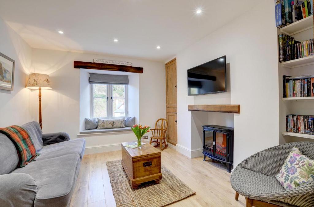 a living room with a couch and a fireplace at Fox Cottage in Lynmouth