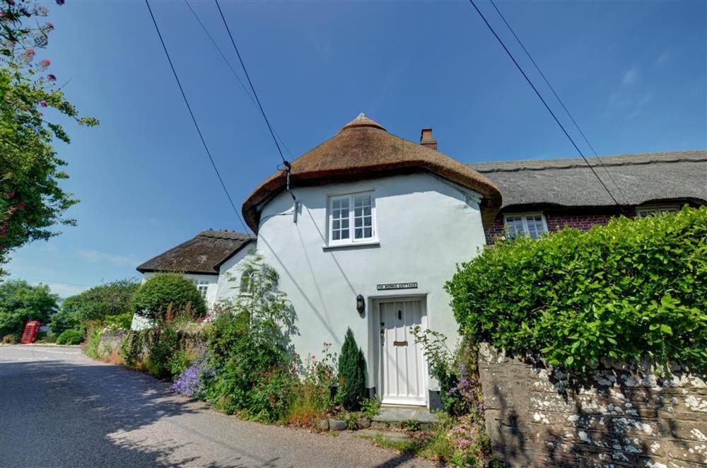 une petite maison blanche avec un toit marron dans l'établissement Monks Cottage, à Braunton