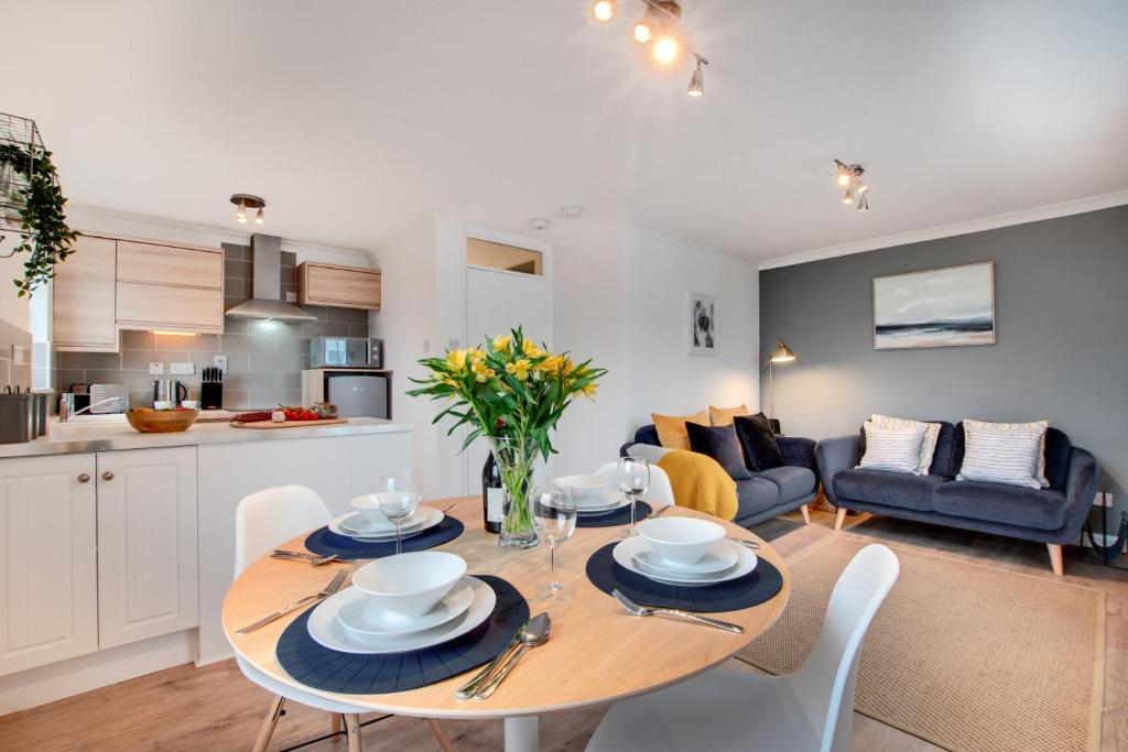 ウーラクームにあるBeach Escapeのテーブルと椅子のあるキッチンとリビングルーム