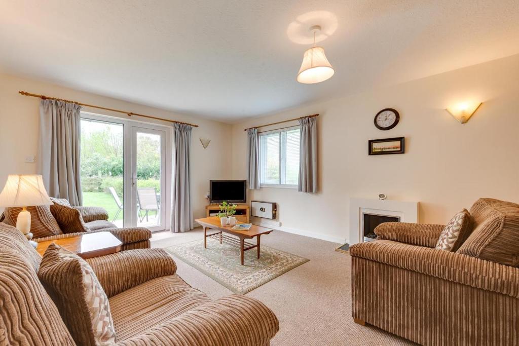 ein Wohnzimmer mit zwei Sofas und einem Tisch in der Unterkunft Spindrift Cottage Berrynarbor in Berrynarbor