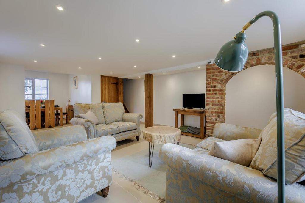 Una sala de estar con dos sofás y una mesa. en Quercus Cottage - Challock, en Leaveland