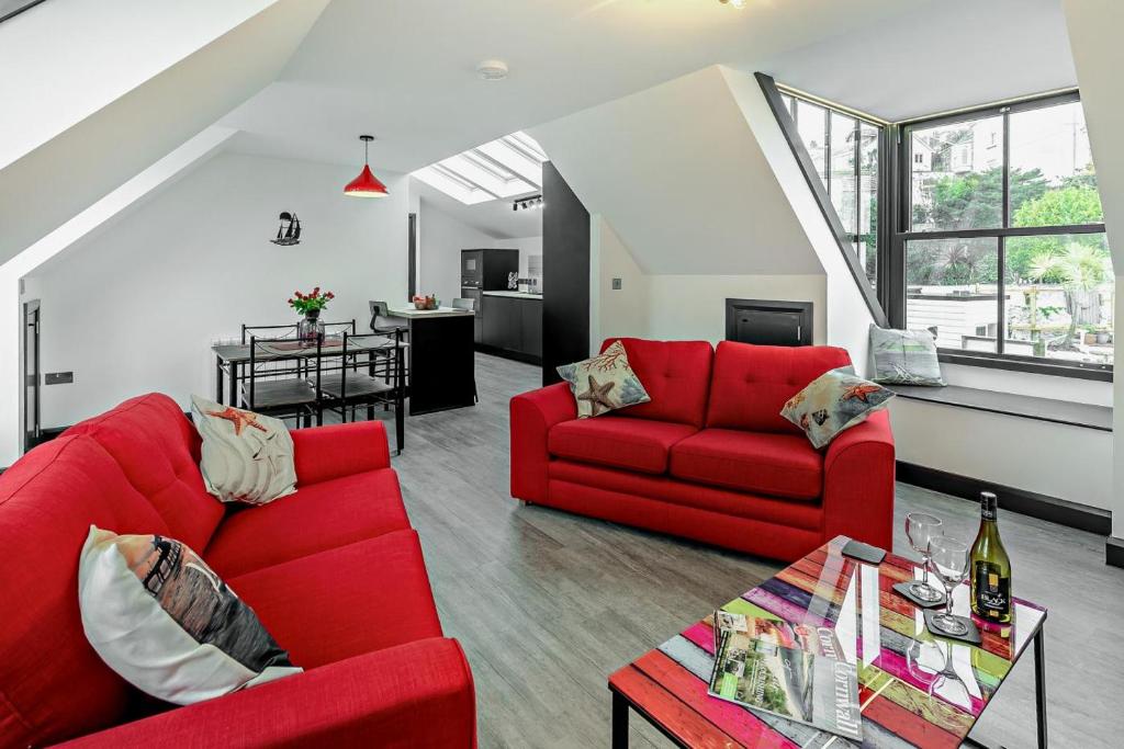 Una sala de estar con dos sofás rojos y una mesa. en Rooftop Rendezvous - St Ives, en St Ives