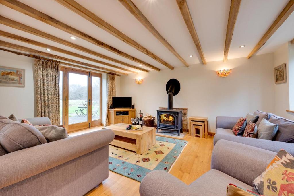 een woonkamer met twee banken en een open haard bij Birdsong Barn in Westfield