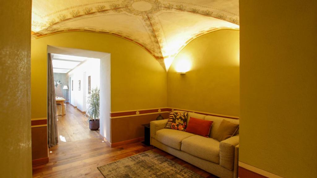 a living room with a couch and a gold ceiling at Casa di Sant'Anselmo Aosta - La Loggia in Aosta