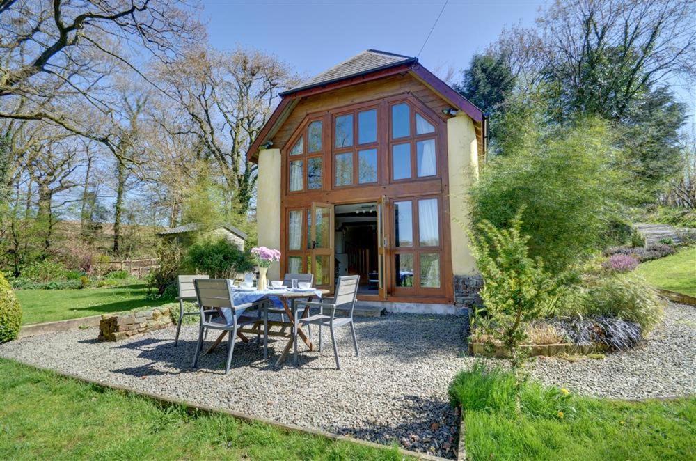 a house with a table and chairs in a garden at 2 Bed in Meshaw oc-meadow in Meshaw