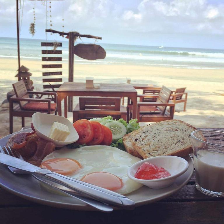 a plate of food with an egg and bread on the beach at JJ Beach Resort & JJ Seafood in Ko Phayam