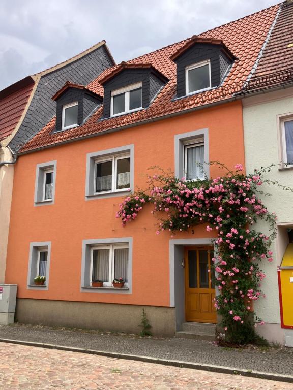 a orange house with flowers in front of it at Beim Stadttor in Belgern