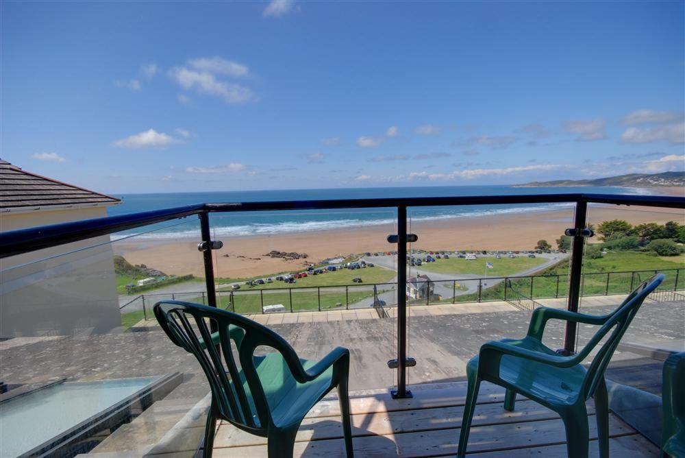 2 sillas en un balcón con vistas a la playa en Flat 24 Clifton Court, en Croyde