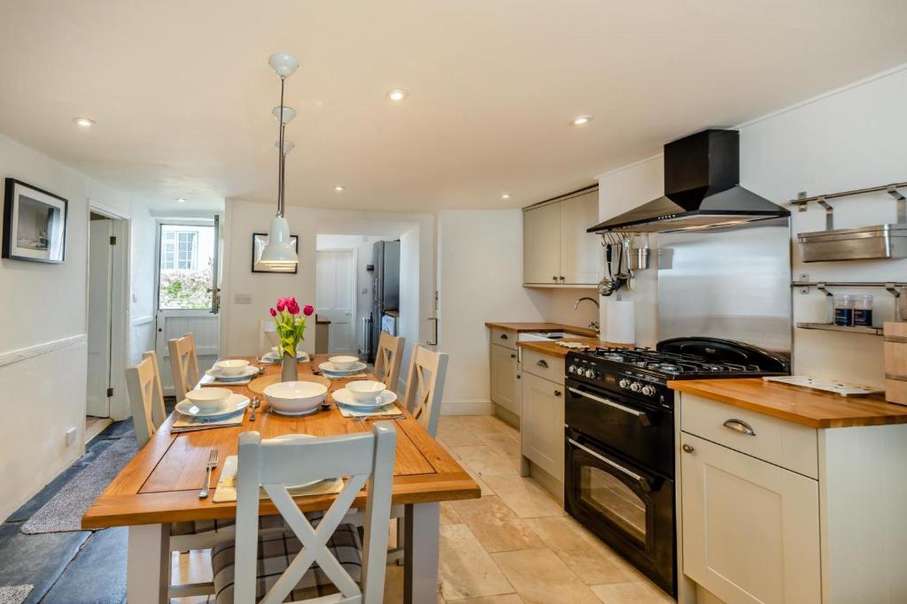 eine Küche mit Holztisch und ein Esszimmer in der Unterkunft Annies Cottage - Appledore in Appledore