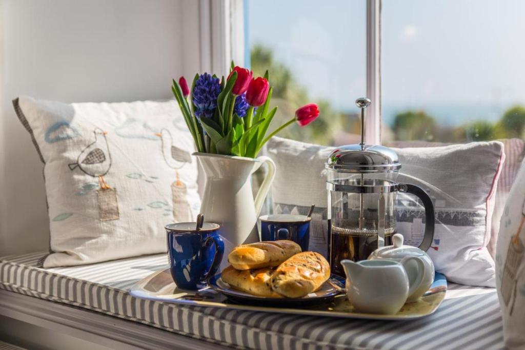 a tray of pastries and flowers on a table at Seahorse Cottage in Mousehole
