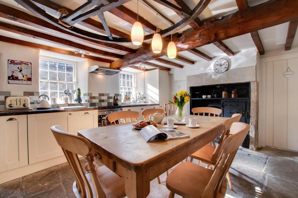 a large kitchen with a wooden table and chairs at Rooks Cottage in Askrigg