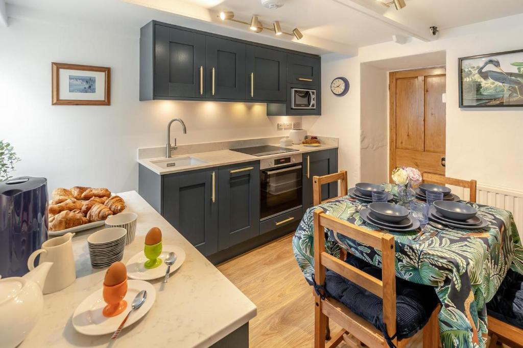 a kitchen with black cabinets and a table in a kitchen at Shell Cottage 10 St Peters Street in St Ives