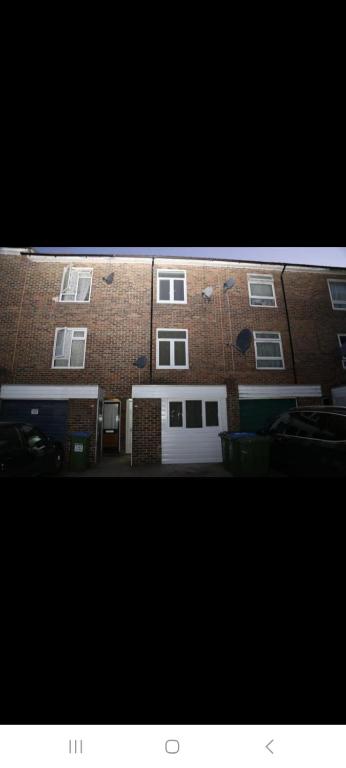 a large brick building with a white garage at Woolwich Ensuite Roomz in Woolwich