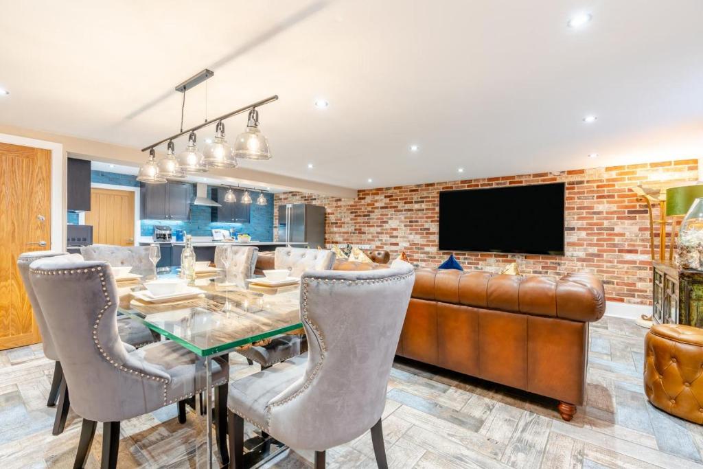 ウィットビーにあるThe Admirals Room - Whitbyのガラスのテーブルとレンガの壁が備わるダイニングルーム