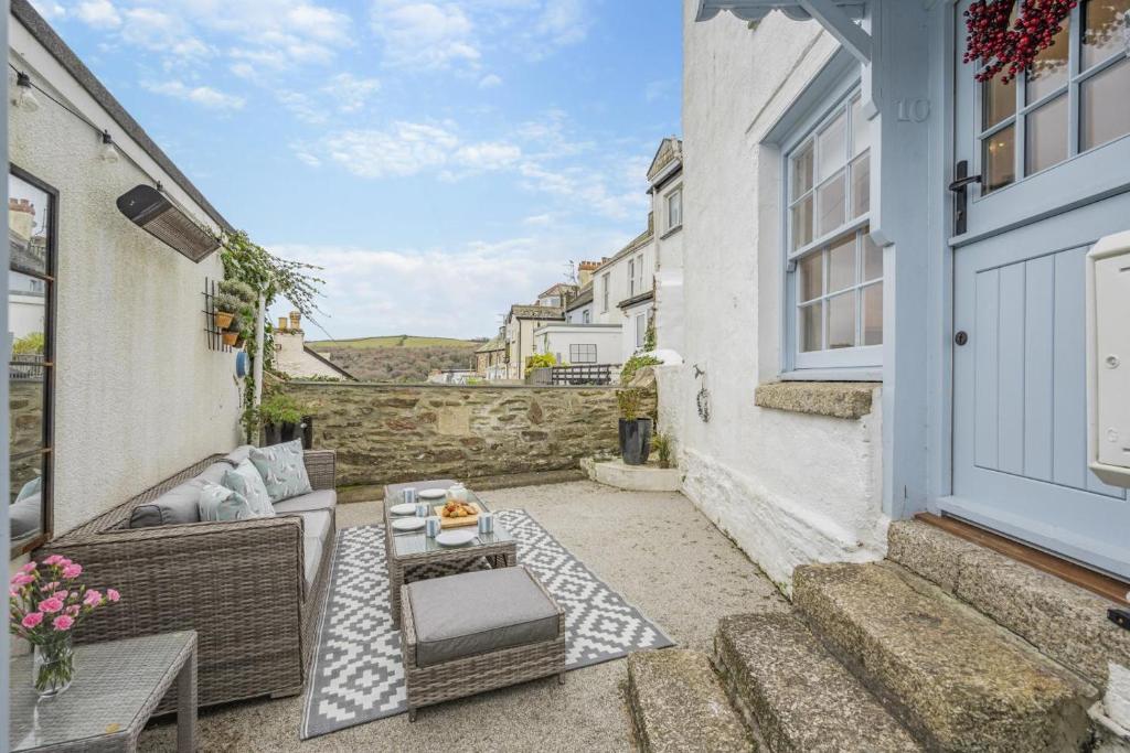 a small patio with a couch and a table at River Watch - Fowey in Fowey