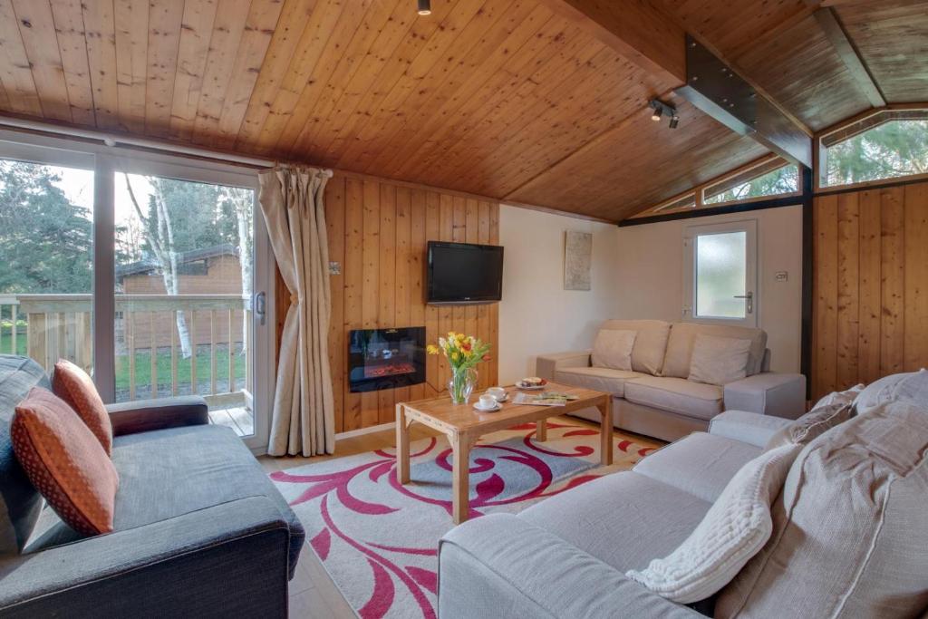 ein Wohnzimmer mit Couch und Tisch in der Unterkunft Birch Lodge in Thornton Watlass