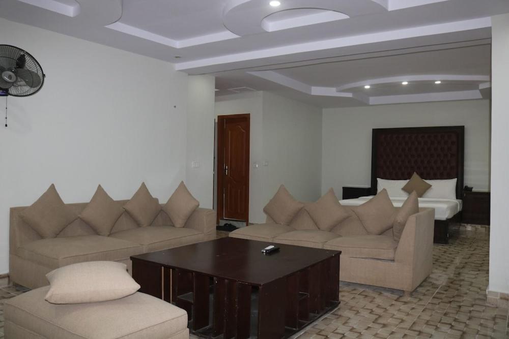 Una sala de estar con dos sofás y una mesa de café. en Royal Blue Hotel, en Islamabad