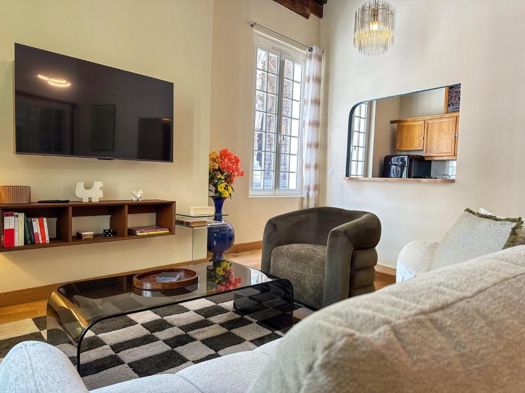 a living room with a couch and a table at VitraNova – Face à la cathédrale de Chartres in Chartres