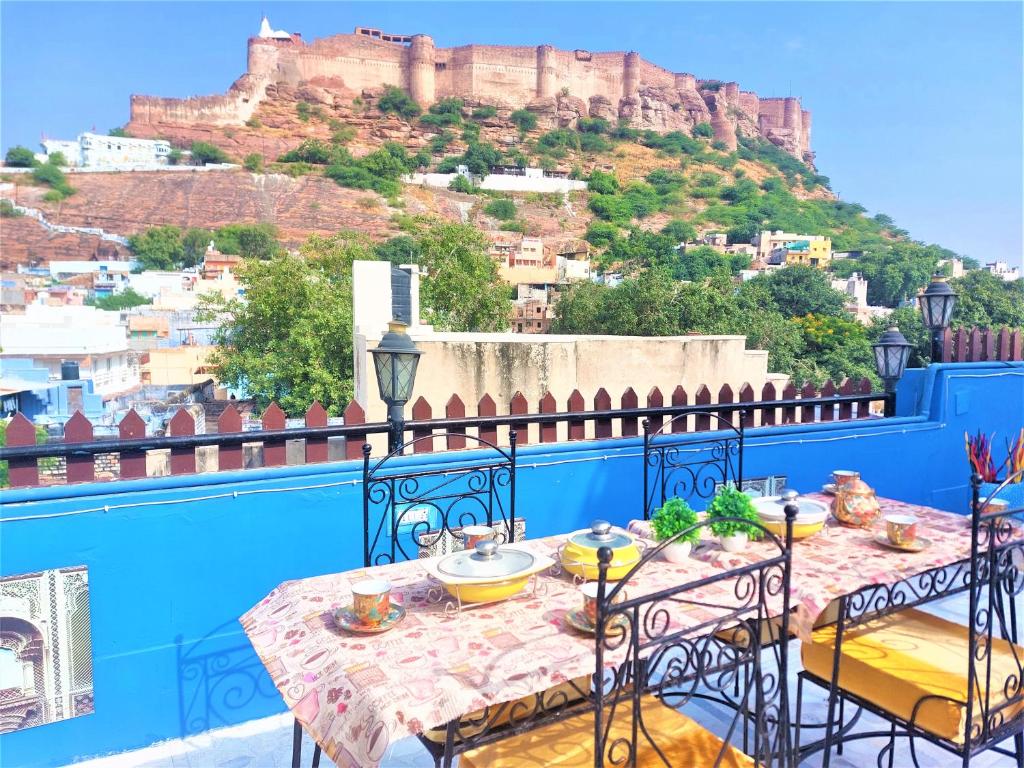 a table on a balcony with a view of a mountain at SAJI SANWRI Heritage Inn Haveli in Jodhpur