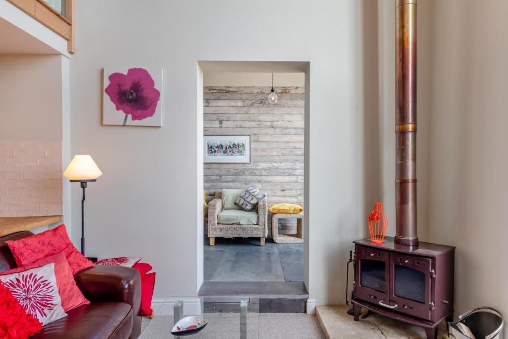 a living room with a couch and a wood stove at The Lodge - Hallmark House in Saint Michaels
