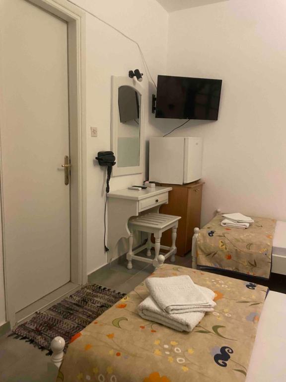 a room with a bed with a desk and a mirror at rigas-zoi 5 in Skiathos Town