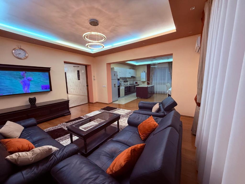 a living room with a couch and a flat screen tv at Alisia House in Sibiu
