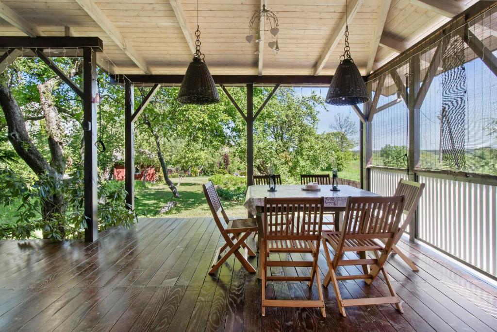 una sala da pranzo con tavolo e sedie su un portico di Odpocznij Na Werandzie a Różan
