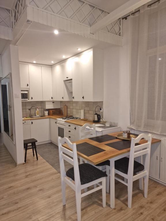 a kitchen with a table and chairs and a kitchen with white cabinets at nocleg w Krośnie blisko dworca in Krosno