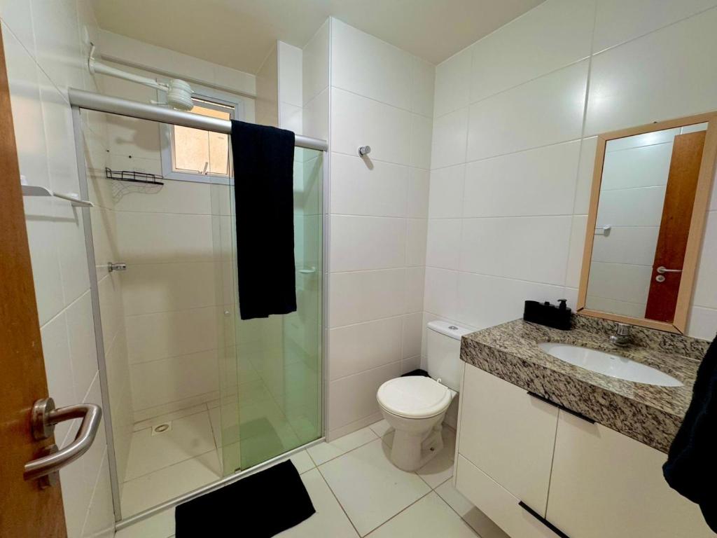 a bathroom with a shower and a toilet and a sink at Apt 2 quartos com Vista Mar Piscina e Varanda 200 m da Praia Ilheus BA in Ilhéus