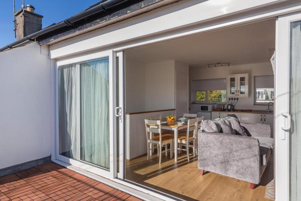a sliding glass door leading to a kitchen and a dining room at 23 Cae Du in Abersoch